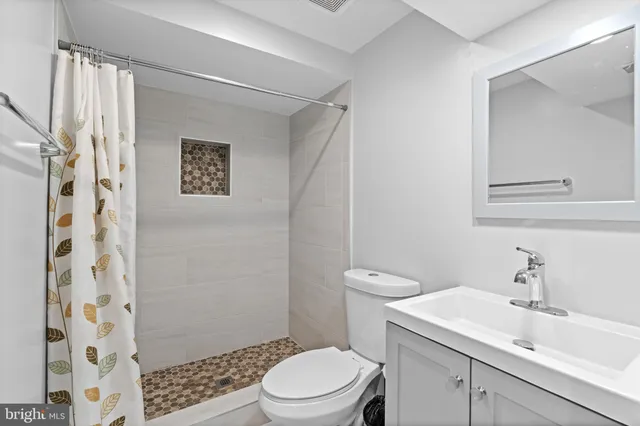 a bathroom with a sink a toilet and shower curtain