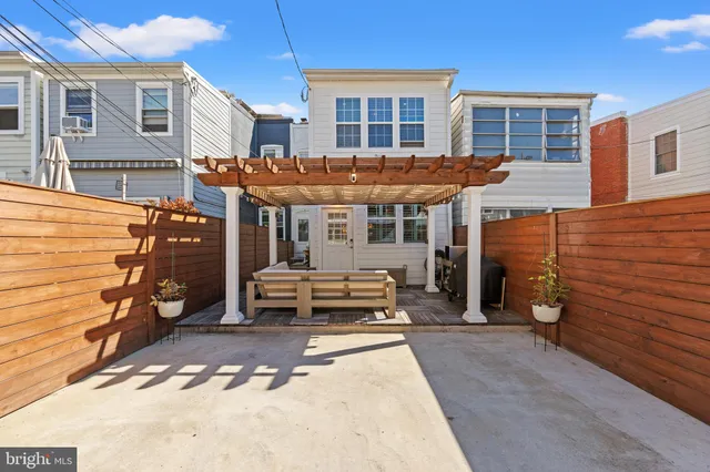 a view of a house with a barbeque and wooden stairs