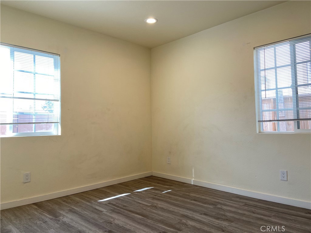 10952 Rose Street Stanton, CA 90680 - Photo 9 of 34 an empty room with wooden floor and windows