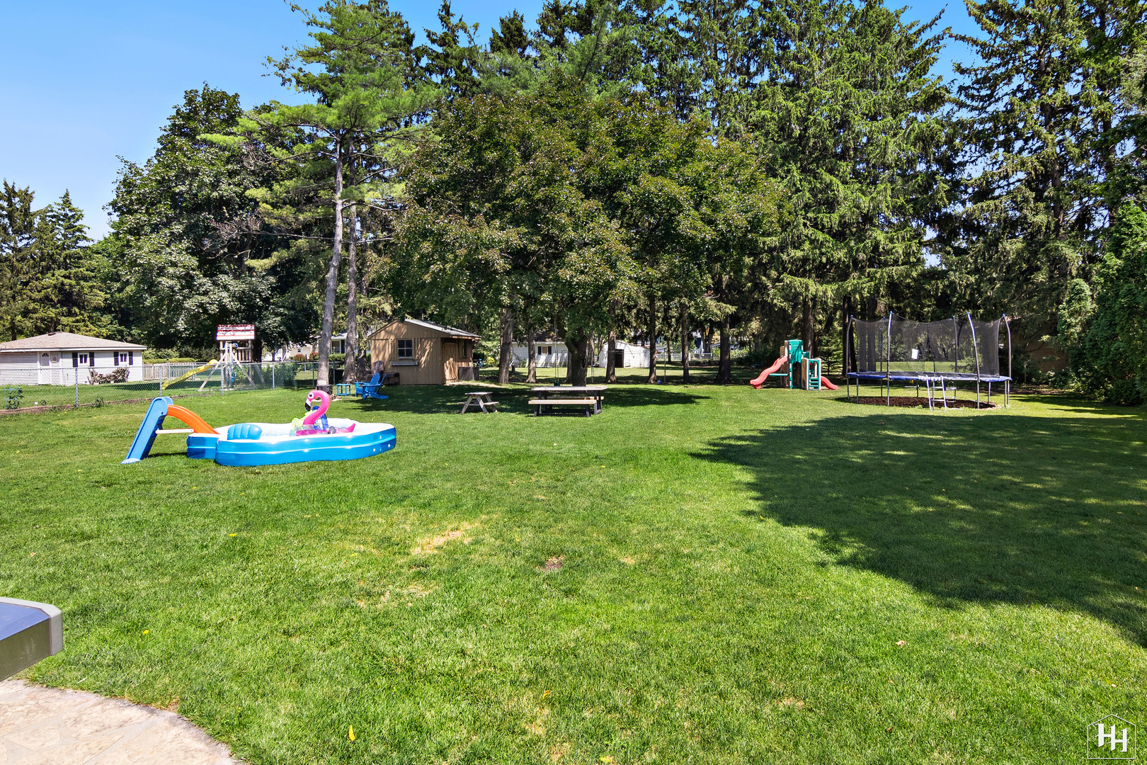 2761 Prairie Road Buffalo Grove, IL 60089 - Photo 21 of 23 a backyard of a house with table and chairs and a large tree