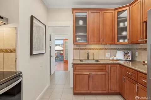 a kitchen with granite countertop a refrigerator and wooden cabinets
