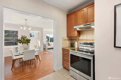 a view of a patio with couches chairs potted plants and wooden floor