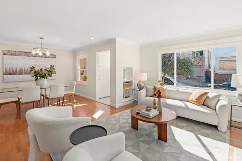 a living room with furniture a table and a large window