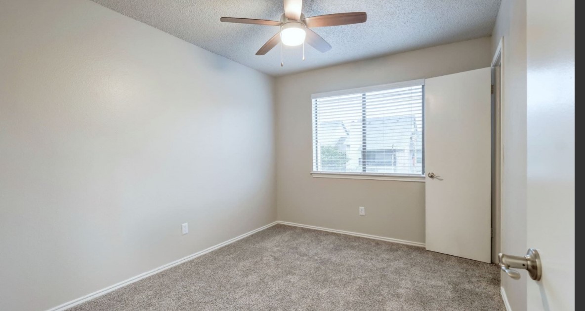 1338 Christopher Avenue, Unit 1230 Round Rock, TX 78681 - Photo 11 of 13 Empty room featuring light carpet, a textured ceiling, and ceiling fan