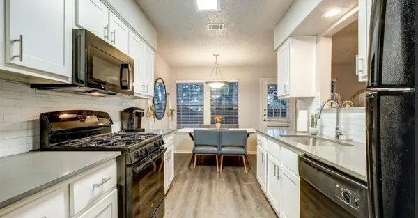 a kitchen with stainless steel appliances a stove sink microwave and cabinets