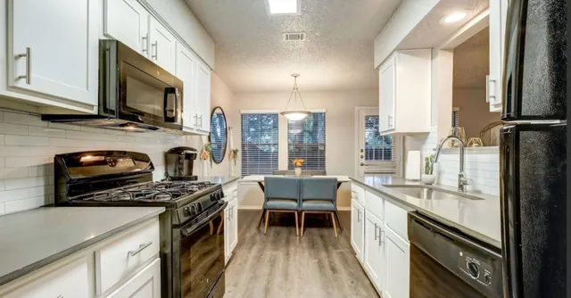 a kitchen with stainless steel appliances a stove sink microwave and cabinets