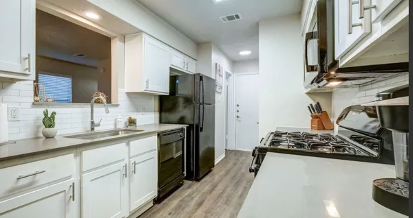 a kitchen with stainless steel appliances kitchen island granite countertop a sink stove and refrigerator
