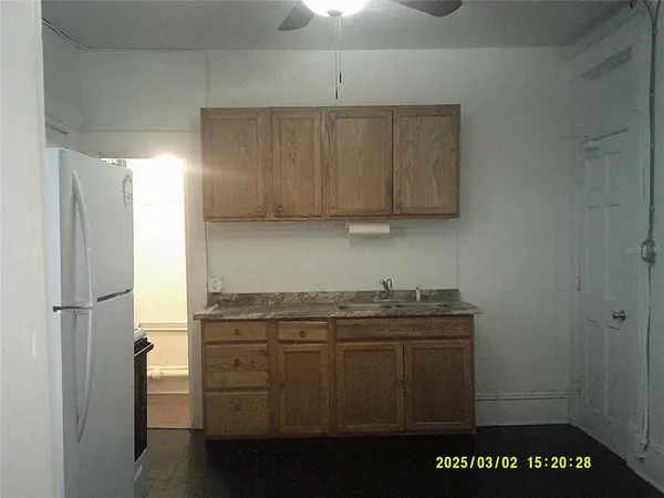a kitchen with stainless steel appliances granite countertop a refrigerator a stove and a sink with wooden cabinets