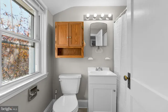 a bathroom with a toilet sink and mirror