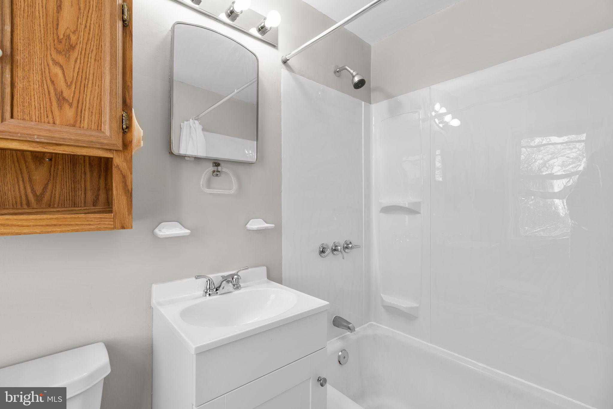 8101 Hillendale Road Baltimore, MD 21234 - Photo 20 of 27 a bathroom with a sink a toilet and shower