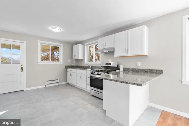 a kitchen with stainless steel appliances granite countertop a stove a sink and a refrigerator