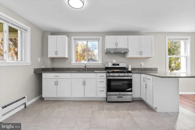 a kitchen with granite countertop white cabinets and appliances