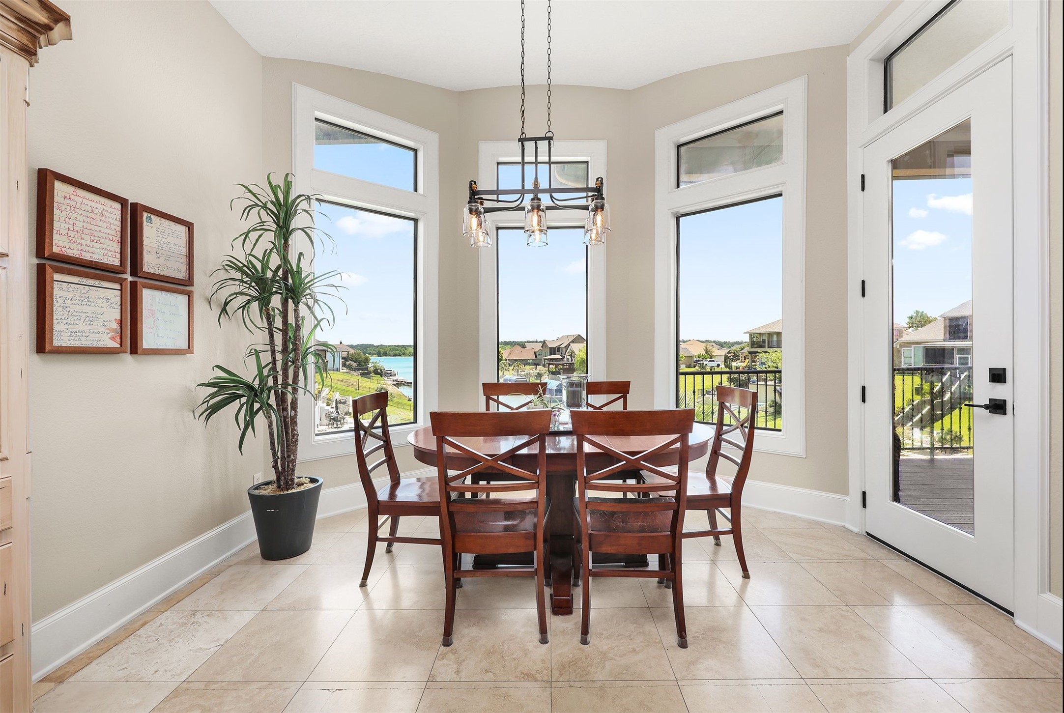 10896 Decatur Street Willis, TX 77318 - Photo 30 of 50 This bright dining area boasts large windows with stunning water views, complemented by a stylish wooden dining set, modern lighting, and elegant tile flooring, creating an inviting and sophisticated space.