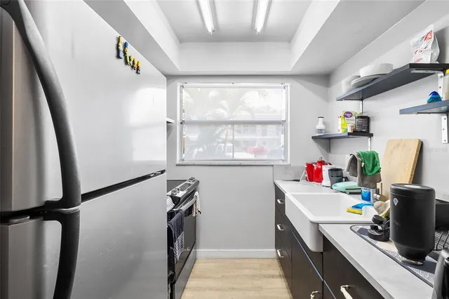 a view of a kitchen with fridge and workspace