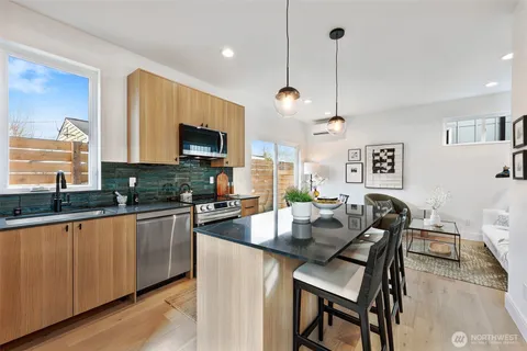 a kitchen with granite countertop a table chairs microwave and sink