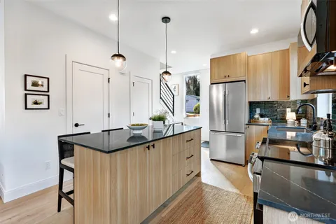 a kitchen with refrigerator a sink a stove and white cabinets