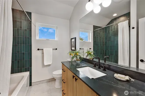 a bathroom with a double vanity sink toilet and shower