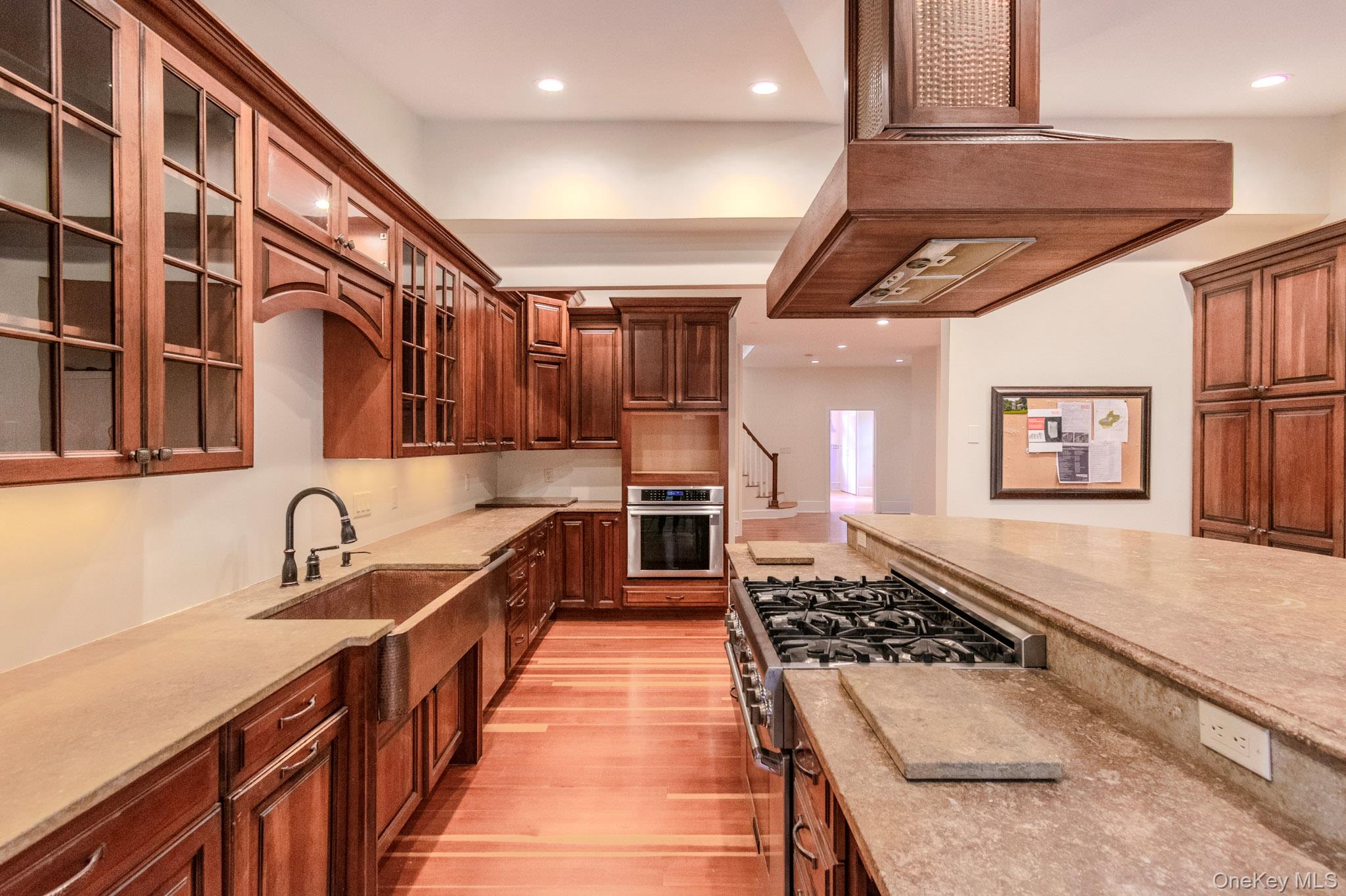 54 East Lake Stable Road Tuxedo Park, NY 10987 - Photo 8 of 31 Kitchen featuring sink, stainless steel appliances, light stone counters, light hardwood / wood-style floors, and custom range hood