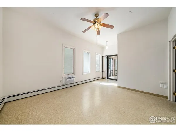 a view of an empty room and chandelier fan