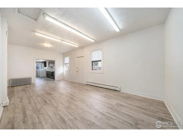 a view of empty room with wooden floor