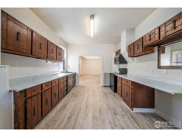 a kitchen with wooden floors and wooden cabinets