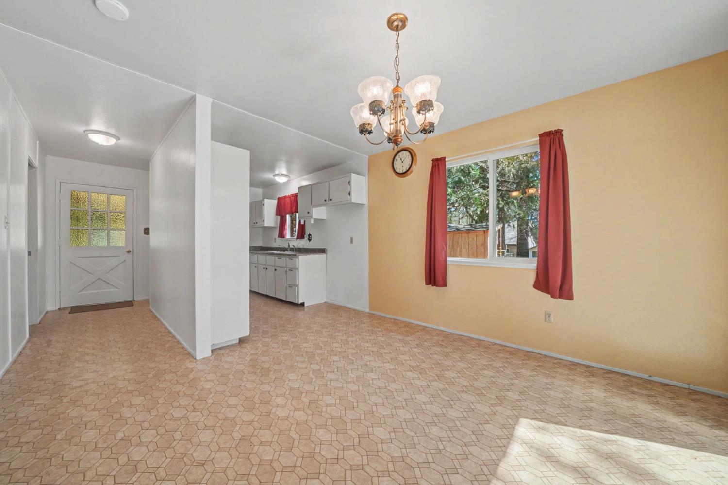 14371 Tobacco Road Pine Grove, CA 95665 - Photo 5 of 38 an empty room with chandelier fan and windows