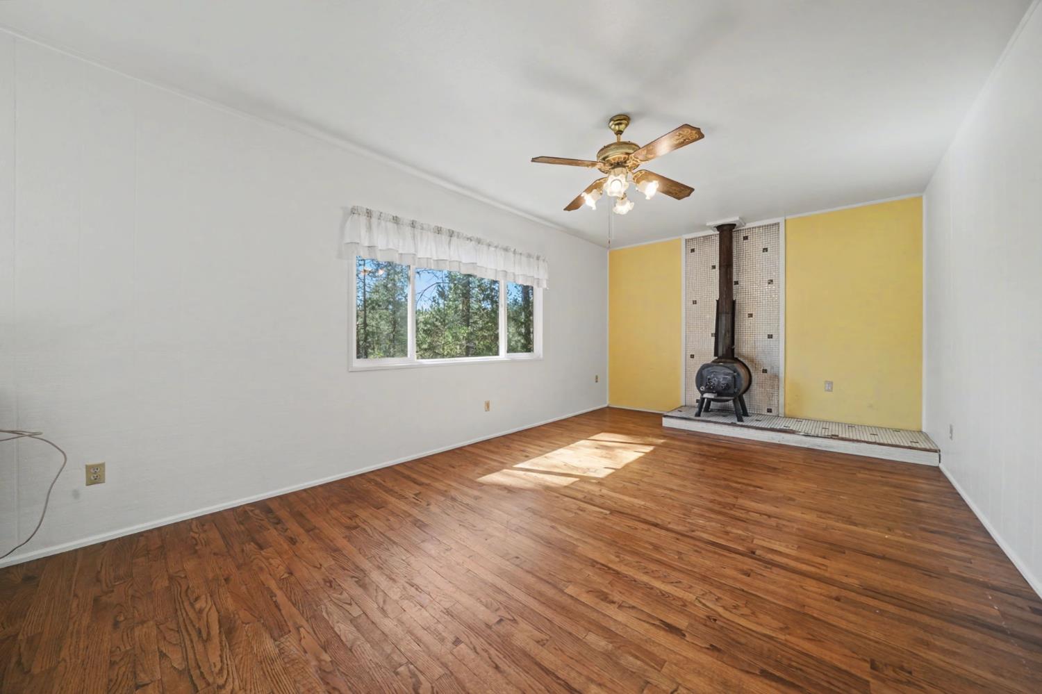 14371 Tobacco Road Pine Grove, CA 95665 - Photo 7 of 38 a view of empty room with wooden floor and fan