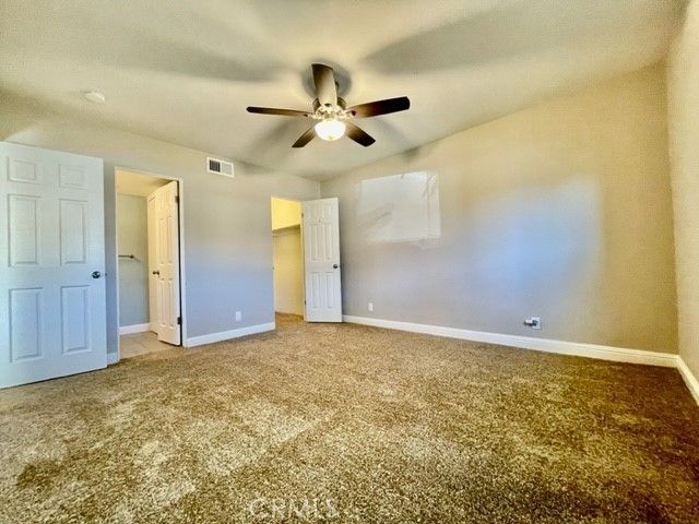 an empty room with closet and a chandelier fan