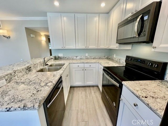 a kitchen with stainless steel appliances granite countertop a sink stove and cabinets