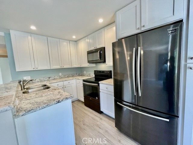 a kitchen with refrigerator a microwave and sink