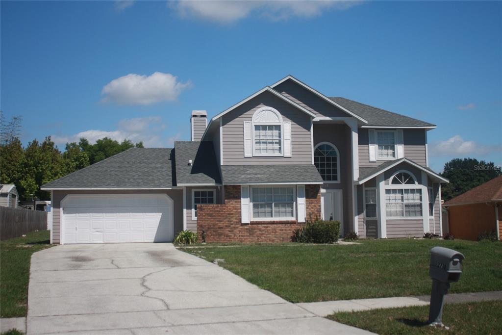a front view of a house with a yard and garage