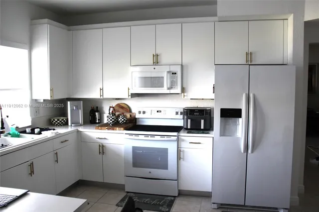 a kitchen with cabinets stainless steel appliances and a window