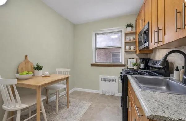 a kitchen with stainless steel appliances granite countertop a sink a stove a table and chairs