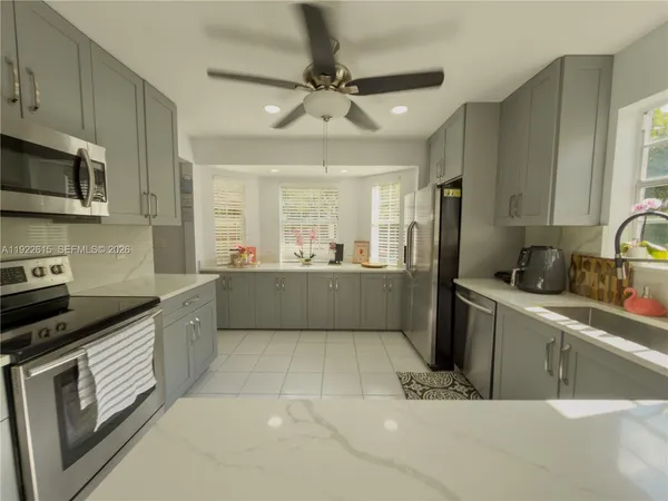 a kitchen with stainless steel appliances a sink a refrigerator and a cabinets