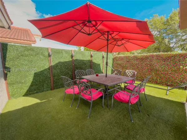 a patio with a table and chairs under an umbrella
