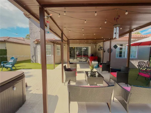 a view of a patio with a table and chairs under an umbrella