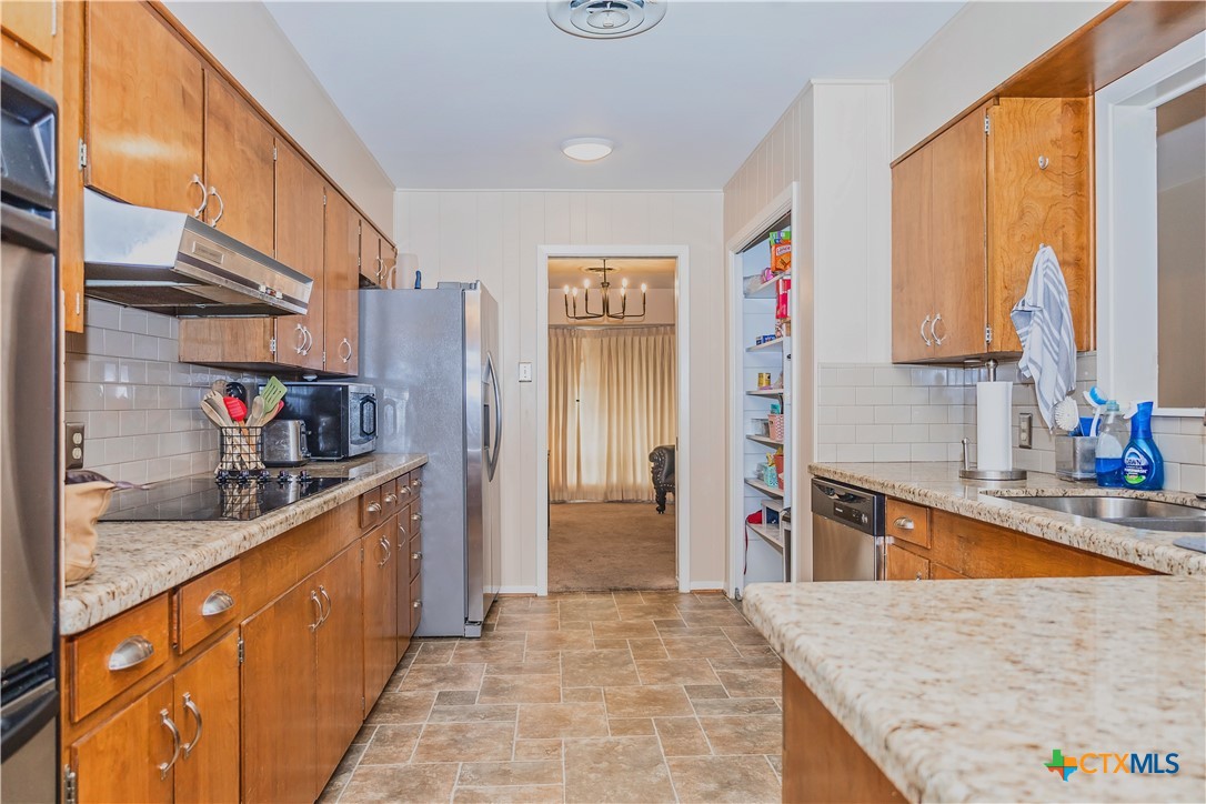 111 Dover Dell Street Victoria, TX 77904 - Photo 13 of 36 a kitchen with stainless steel appliances granite countertop a sink and a refrigerator