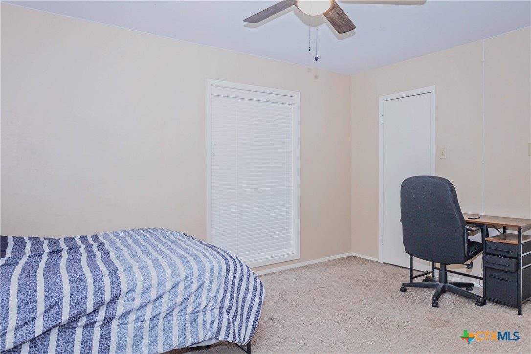 111 Dover Dell Street Victoria, TX 77904 - Photo 35 of 36 a bedroom with a bed a chair and a potted plant