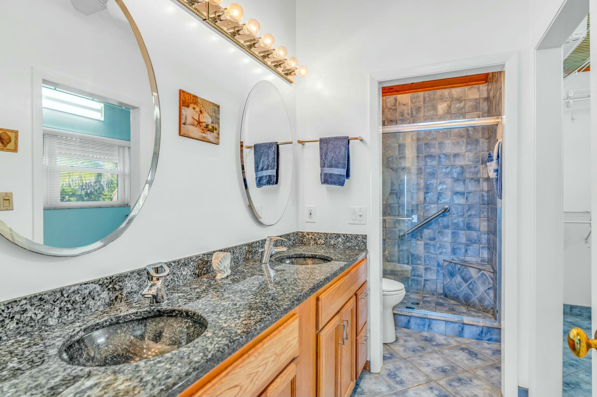 1073 Long Beach Drive Big Pine Key, FL 33043 - Photo 25 of 55 a bathroom with a granite countertop sink a mirror and shower