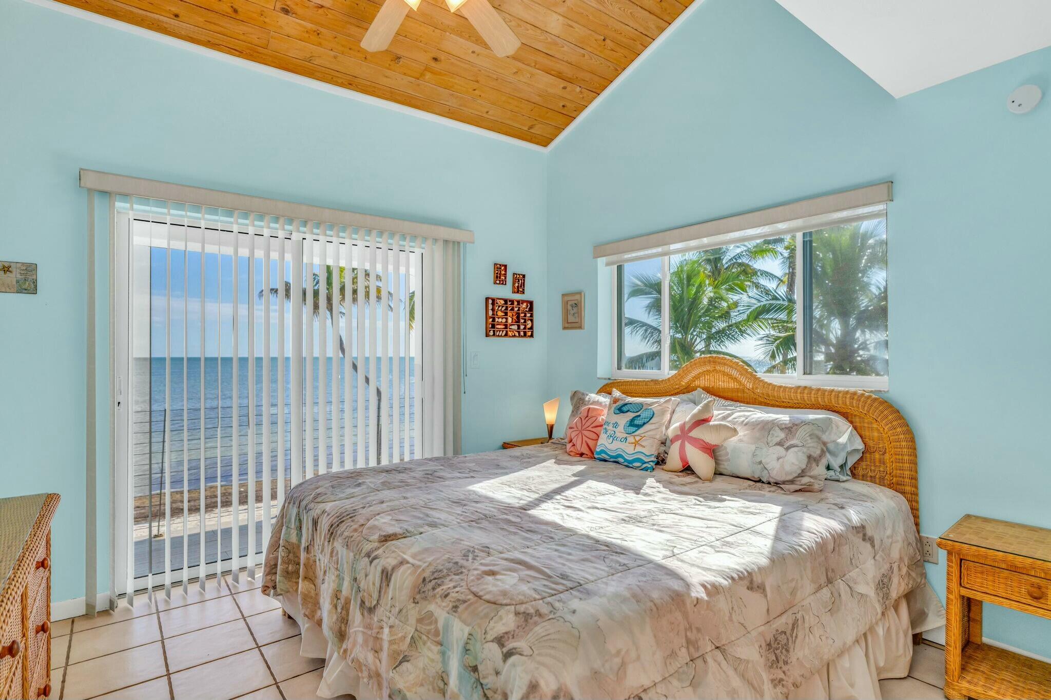 1073 Long Beach Drive Big Pine Key, FL 33043 - Photo 28 of 55 a bedroom with a bed and wooden floor
