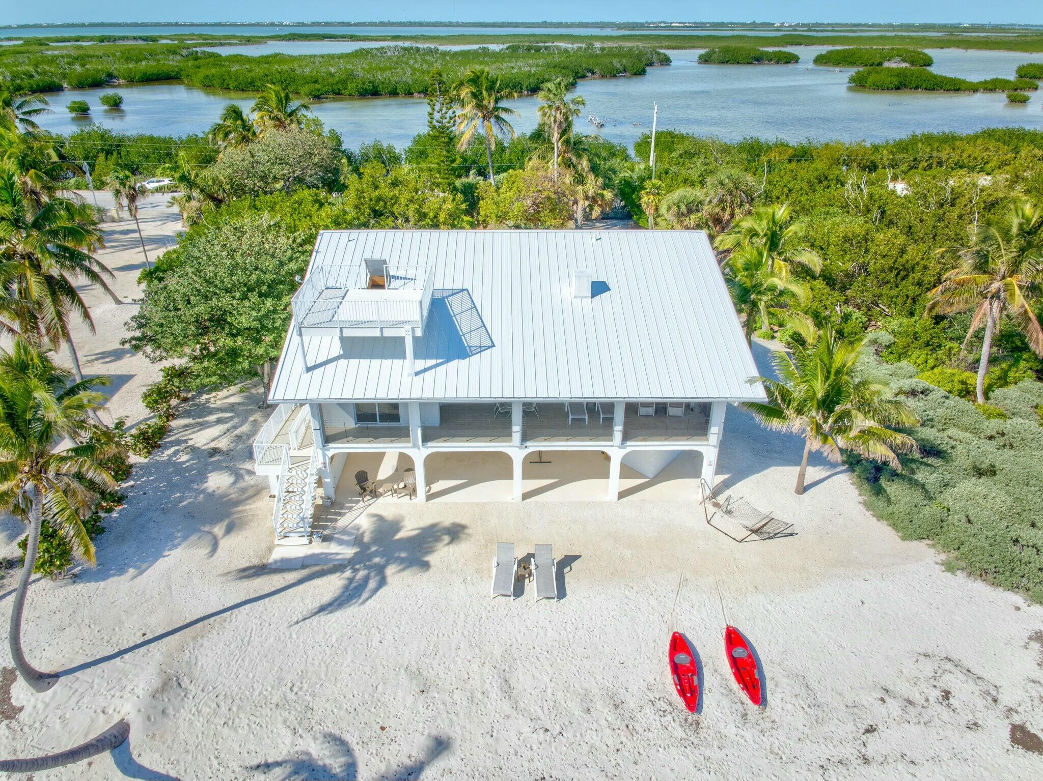 1073 Long Beach Drive Big Pine Key, FL 33043 - Photo 46 of 55 view of outdoor space with seating area and trees in the background