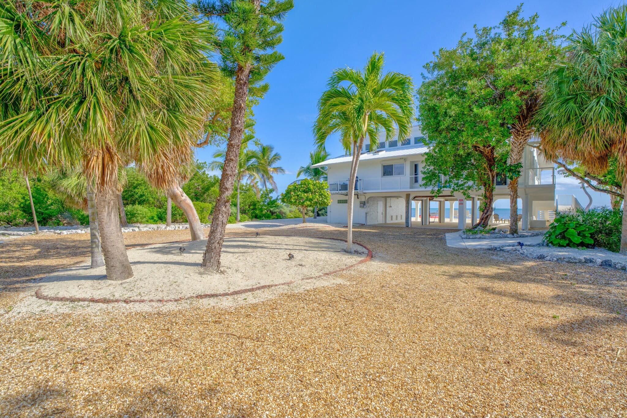 1073 Long Beach Drive Big Pine Key, FL 33043 - Photo 6 of 55 a backyard of a house with table and chairs