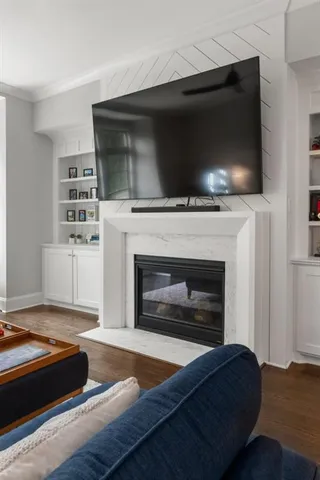 a kitchen with stainless steel appliances granite countertop a sink a stove a refrigerator and white cabinets with wooden floor