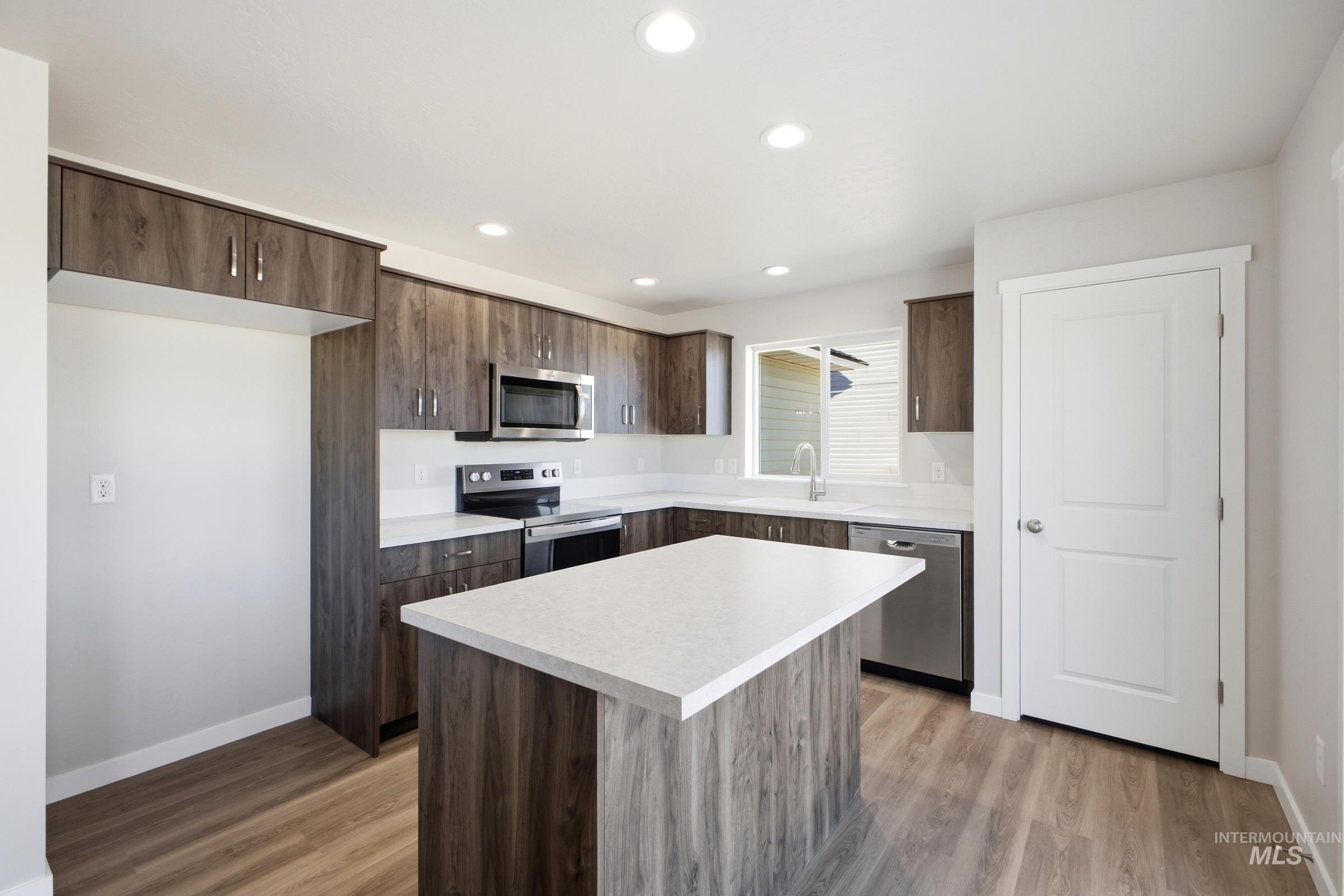 13325 Scrape Street Caldwell, ID 83607 - Photo 3 of 24 Kitchen featuring wood-finish cabinetry, white countertops, stainless steel appliances, and a central island