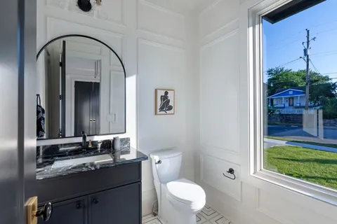 a bathroom with a sink a toilet and a mirror