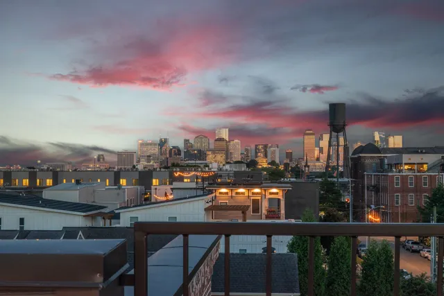 a living room with furniture a large window and wooden floor