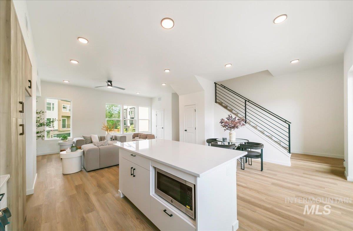 2032 South Mackinnon Lane Boise, ID 83706 - Photo 19 of 48 Kitchen with light wood-style flooring, recessed lighting, stainless steel microwave, a center island, and white cabinetry