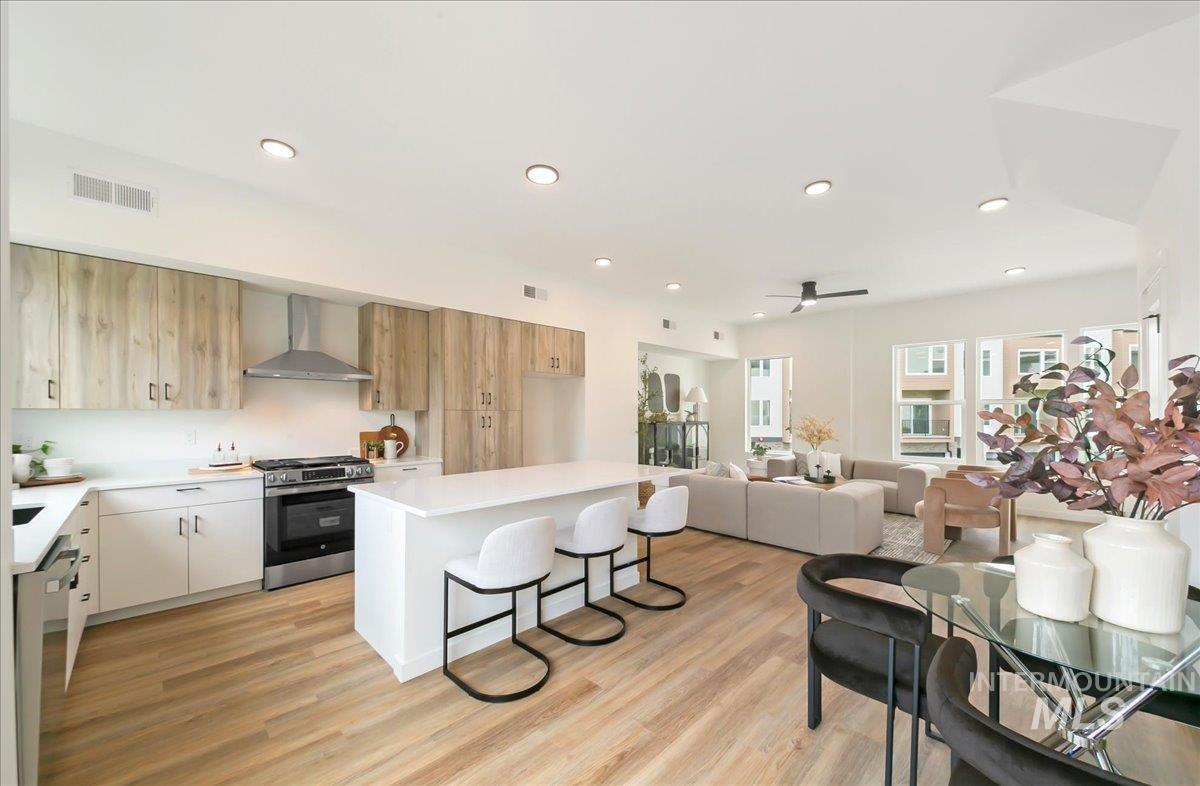 2032 South Mackinnon Lane Boise, ID 83706 - Photo 21 of 48 Kitchen with a breakfast bar area, appliances with stainless steel finishes, modern cabinets, a kitchen island, and wall chimney range hood