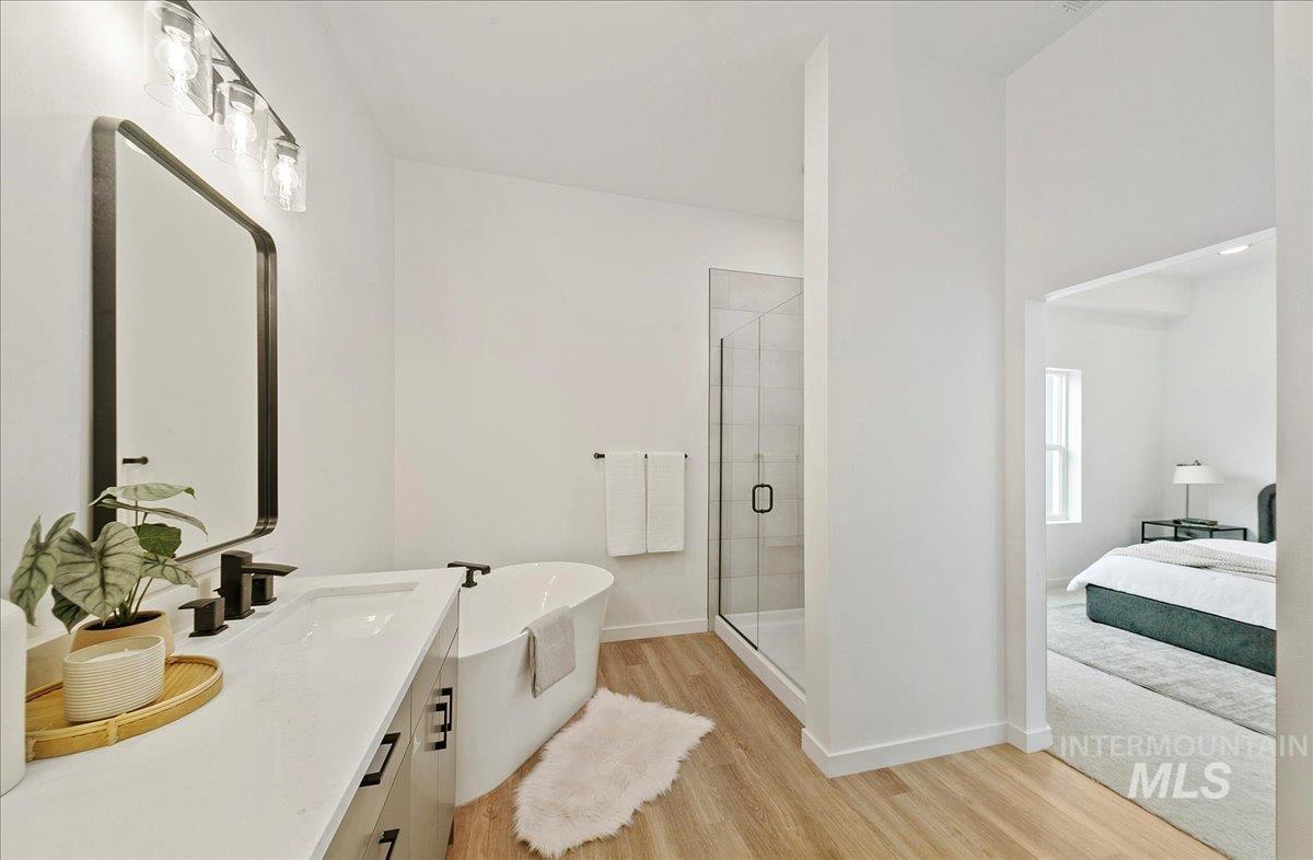 2032 South Mackinnon Lane Boise, ID 83706 - Photo 28 of 48 Full bathroom with light wood-type flooring, a shower stall, a soaking tub, vanity, and ensuite bath