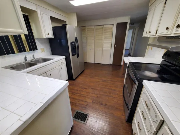a kitchen with sink and refrigerator